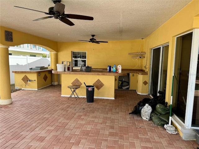 view of patio / terrace featuring ceiling fan and an outdoor bar