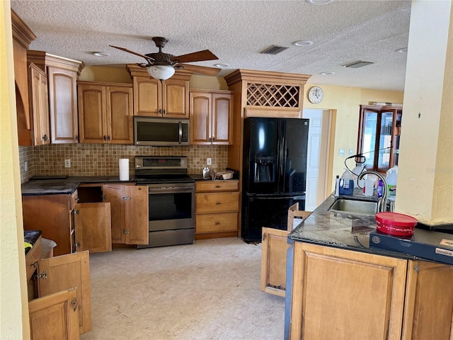 kitchen with ceiling fan, a textured ceiling, sink, and appliances with stainless steel finishes