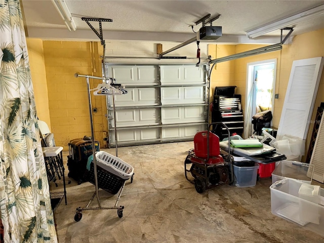 garage featuring a garage door opener and concrete block wall