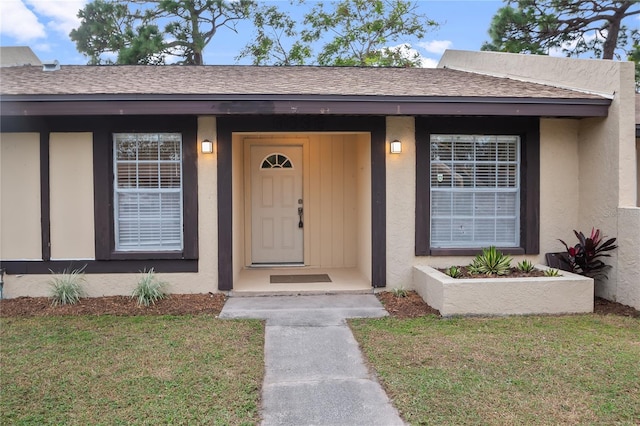 entrance to property with a lawn