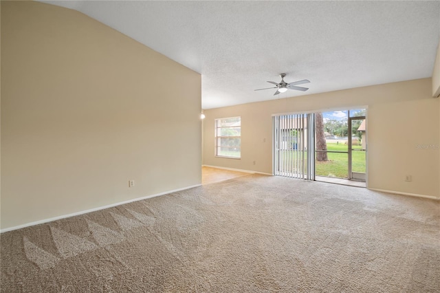 carpeted empty room featuring lofted ceiling, a textured ceiling, and ceiling fan