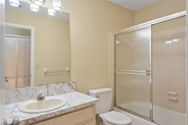 full bathroom with shower / bath combination with glass door, toilet, and vanity