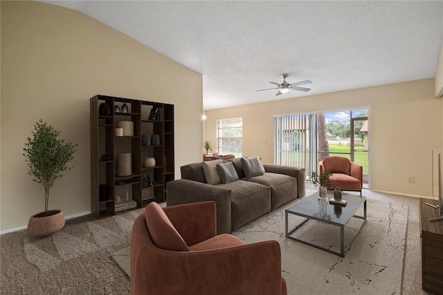 living area with vaulted ceiling, carpet floors, a ceiling fan, and baseboards