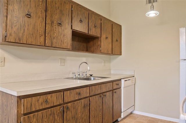 kitchen featuring a sink, baseboards, light countertops, and dishwasher