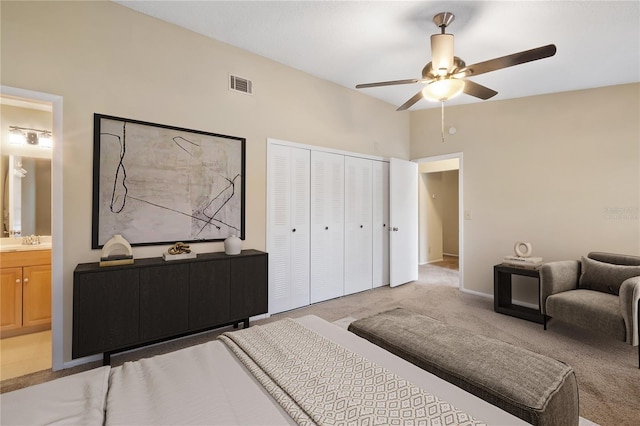 bedroom featuring ensuite bathroom, carpet floors, a sink, visible vents, and a closet