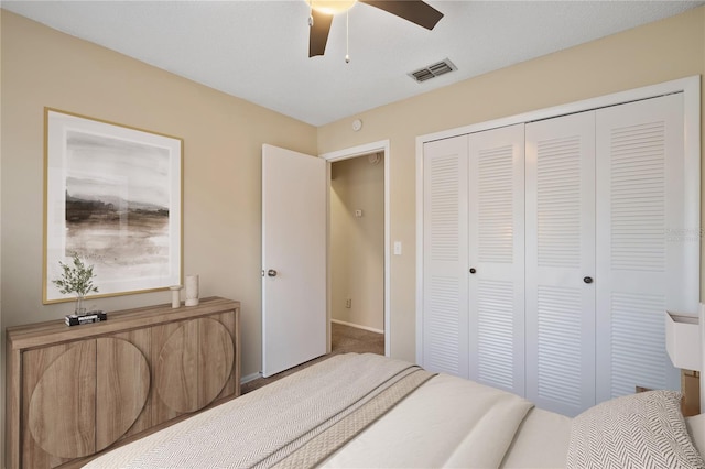 bedroom with baseboards, ceiling fan, visible vents, and a closet