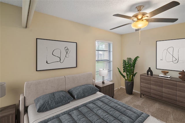 bedroom featuring ceiling fan, a textured ceiling, baseboards, and carpet flooring