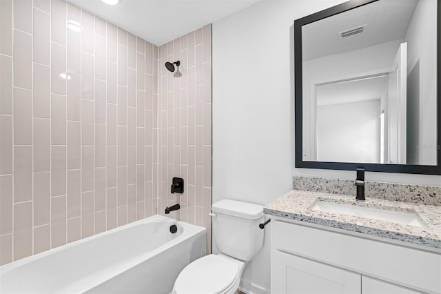 full bathroom featuring vanity, tiled shower / bath, and toilet