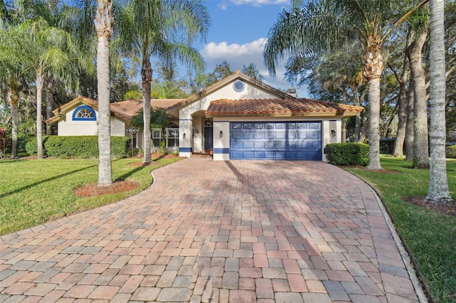 mediterranean / spanish house with a garage and a front lawn