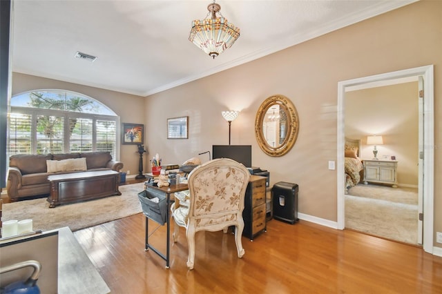 living room featuring a chandelier, hardwood / wood-style floors, and ornamental molding