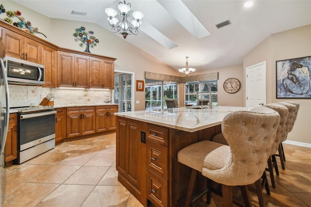 kitchen featuring pendant lighting, a chandelier, a large island with sink, and stainless steel appliances