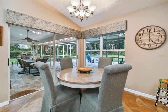 dining room with ceiling fan with notable chandelier and vaulted ceiling