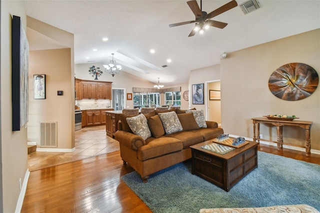 living room featuring ceiling fan with notable chandelier, light hardwood / wood-style flooring, and vaulted ceiling with beams