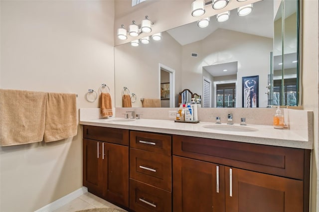 bathroom featuring vanity, tile patterned floors, and vaulted ceiling