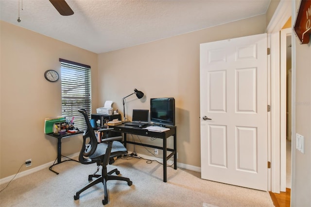 home office featuring ceiling fan, light colored carpet, and a textured ceiling