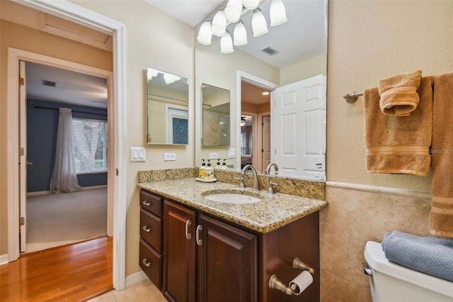 bathroom with hardwood / wood-style flooring, vanity, and toilet