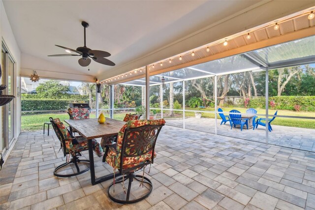 view of patio featuring ceiling fan and a lanai