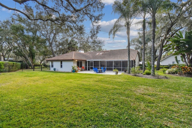 back of property featuring a lawn, a patio, and a sunroom