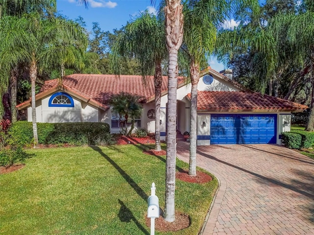 mediterranean / spanish home featuring a garage and a front yard