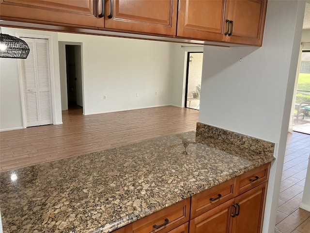 kitchen with dark stone counters and hardwood / wood-style flooring