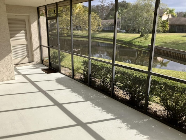 unfurnished sunroom featuring a water view