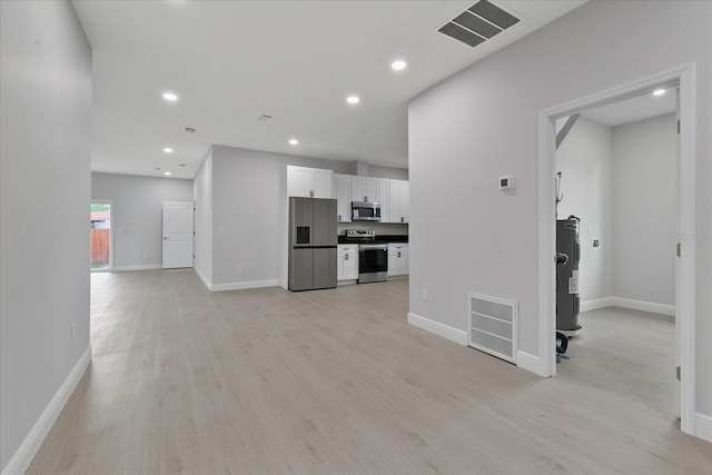 unfurnished living room with water heater and light hardwood / wood-style flooring