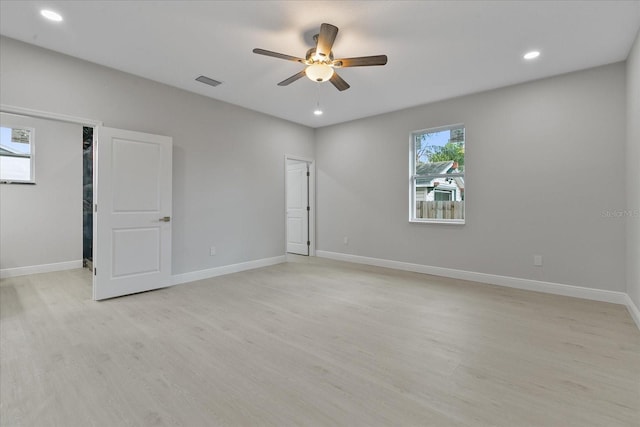 empty room with ceiling fan and light hardwood / wood-style flooring