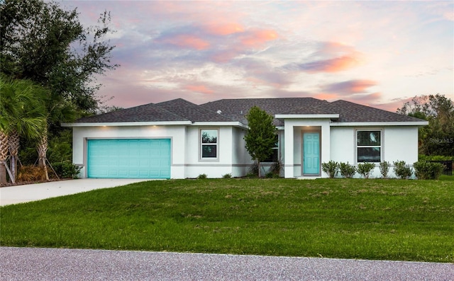 view of front of house with a garage and a yard