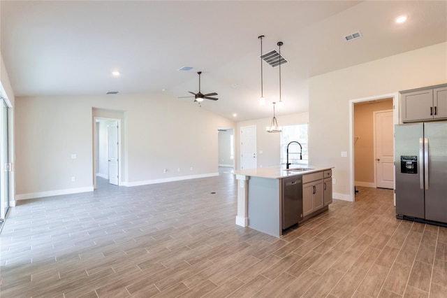 kitchen with light hardwood / wood-style floors, a center island with sink, sink, appliances with stainless steel finishes, and lofted ceiling