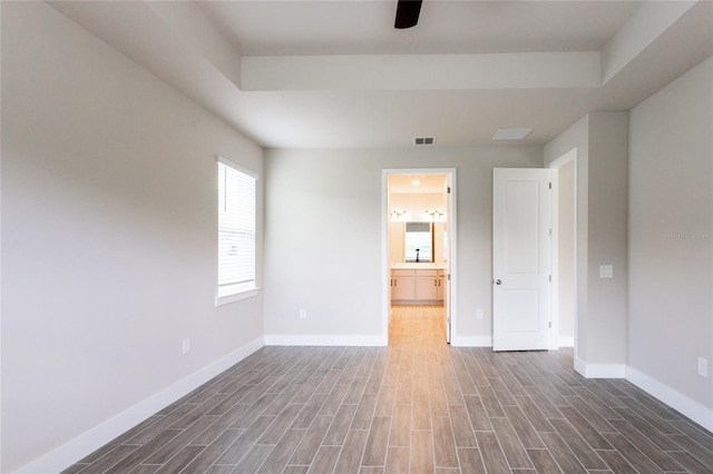 unfurnished room featuring dark hardwood / wood-style floors and a raised ceiling