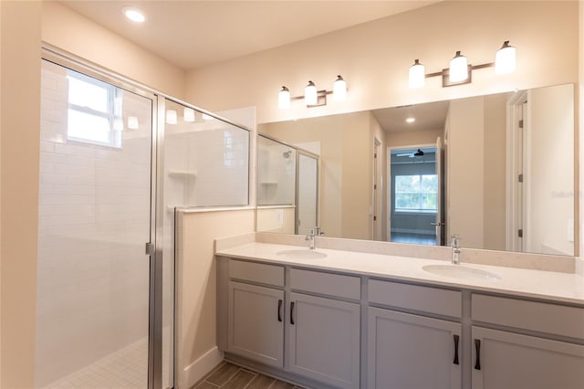 bathroom with vanity, wood-type flooring, a healthy amount of sunlight, and a shower with shower door