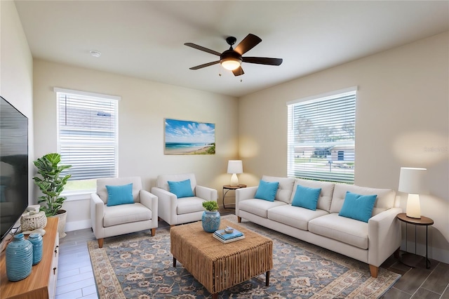 living room with ceiling fan, a wealth of natural light, and dark hardwood / wood-style floors