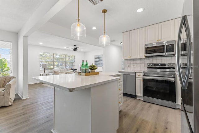 kitchen with light wood-type flooring, white cabinets, ceiling fan, and stainless steel appliances