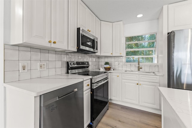 kitchen featuring stainless steel appliances, white cabinetry, and sink