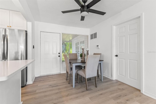 dining space featuring light hardwood / wood-style floors, ceiling fan, and a textured ceiling