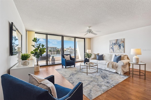 living room with hardwood / wood-style floors, a textured ceiling, floor to ceiling windows, and ceiling fan