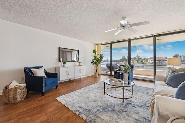 living room featuring a textured ceiling, dark hardwood / wood-style floors, floor to ceiling windows, and ceiling fan