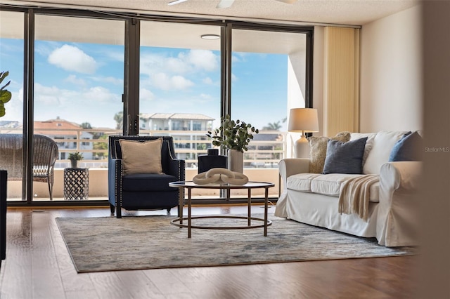 living area featuring a textured ceiling, ceiling fan, dark wood-type flooring, and floor to ceiling windows