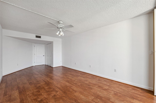 unfurnished room with ceiling fan, dark hardwood / wood-style flooring, and a textured ceiling