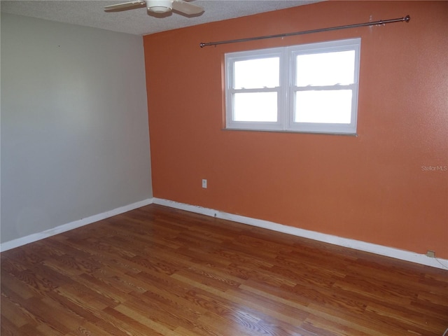 empty room featuring ceiling fan, wood-type flooring, and a textured ceiling