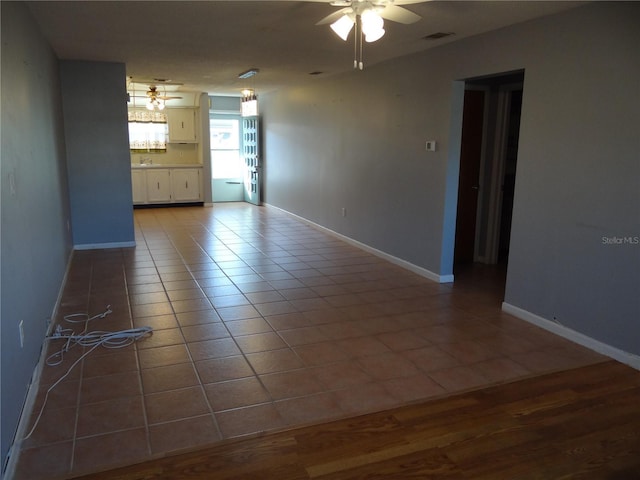 tiled empty room featuring ceiling fan and sink