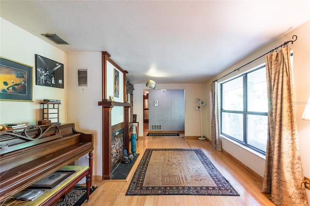 doorway featuring light hardwood / wood-style floors and a textured ceiling