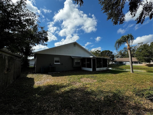 back of property with a sunroom, a yard, and cooling unit