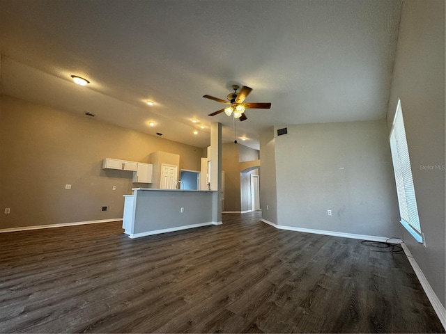 unfurnished living room featuring lofted ceiling, dark hardwood / wood-style floors, and ceiling fan