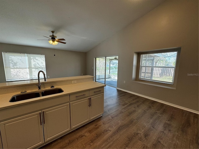 kitchen with white cabinetry, sink, ceiling fan, dark hardwood / wood-style floors, and vaulted ceiling