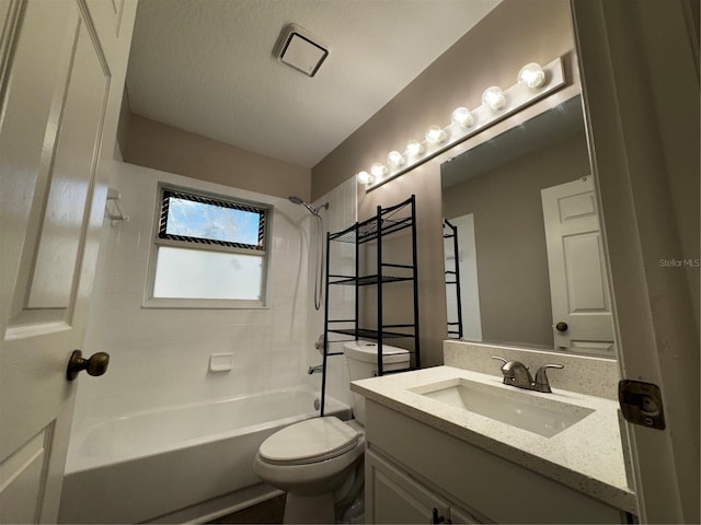 full bathroom featuring vanity, toilet, a textured ceiling, and tiled shower / bath combo