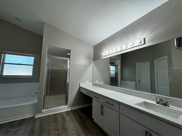 bathroom with independent shower and bath, lofted ceiling, hardwood / wood-style flooring, and vanity