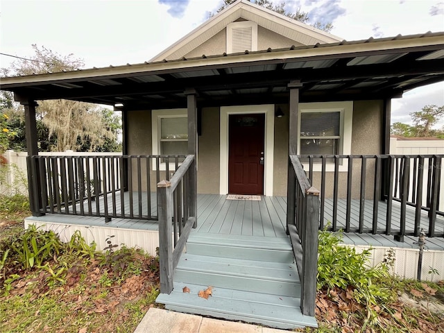 view of exterior entry with a porch