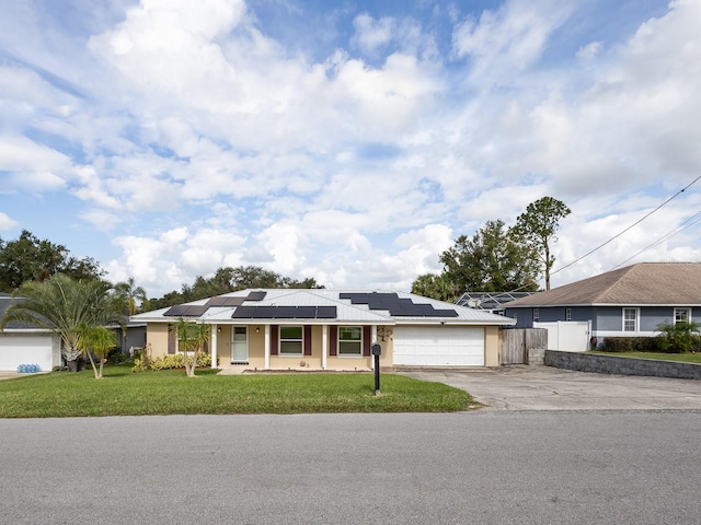 ranch-style home featuring a front lawn, a garage, and solar panels