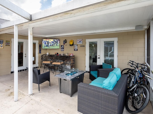 view of patio / terrace featuring an outdoor living space with a fire pit and french doors